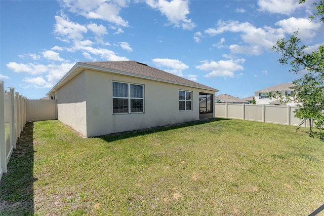 947 Serchio St, Haines City, FL 33844 - rear view of house featuring roof with shingles, stucco siding, a fenced backyard, and a lawn
