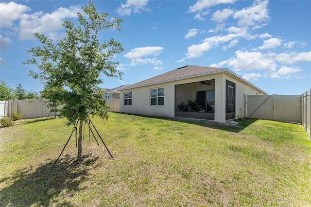 947 Serchio St, Haines City, FL 33844 - rear view of property featuring a lawn, a fenced backyard, stucco siding, and a gate