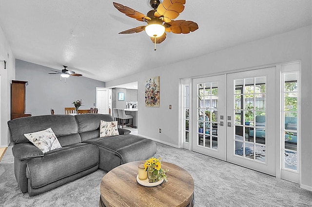 carpeted living area featuring a ceiling fan, baseboards, french doors, and vaulted ceiling