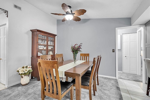 dining space featuring light colored carpet, visible vents, ceiling fan, light tile patterned floors, and baseboards