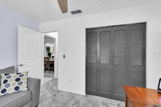 interior space featuring visible vents, baseboards, a ceiling fan, and light carpet