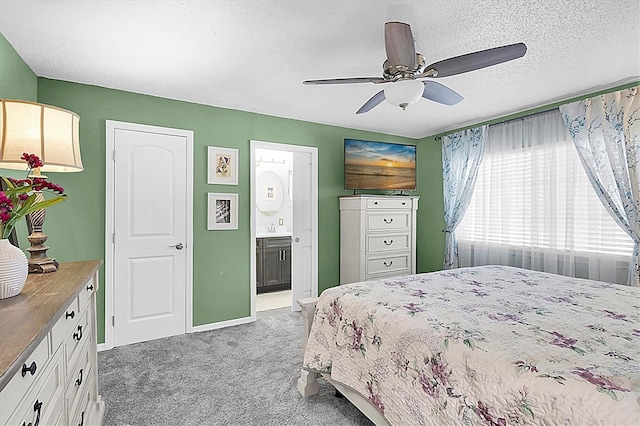 bedroom featuring carpet, a sink, a textured ceiling, ensuite bathroom, and ceiling fan