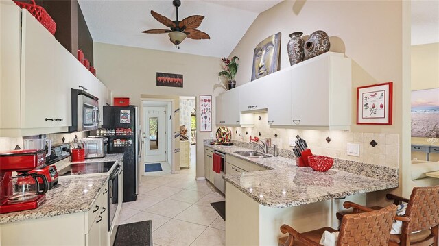 6148 Bonaventure Ct, Sarasota, FL 34243 - kitchen featuring white cabinets, a sink, decorative backsplash, a peninsula, and appliances with stainless steel finishes