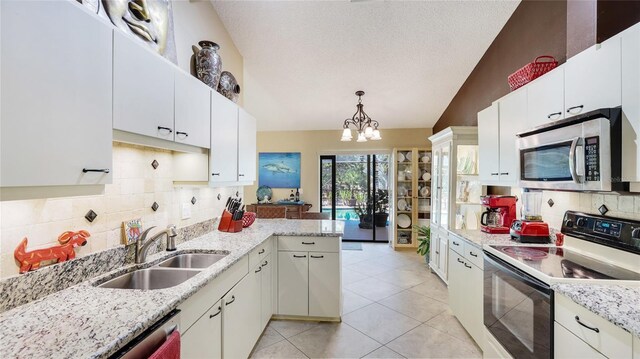 6148 Bonaventure Ct, Sarasota, FL 34243 - kitchen featuring stainless steel appliances, vaulted ceiling, a sink, a chandelier, and tasteful backsplash