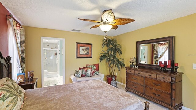 6148 Bonaventure Ct, Sarasota, FL 34243 - bedroom with visible vents, a ceiling fan, baseboards, a textured ceiling, and ensuite bathroom