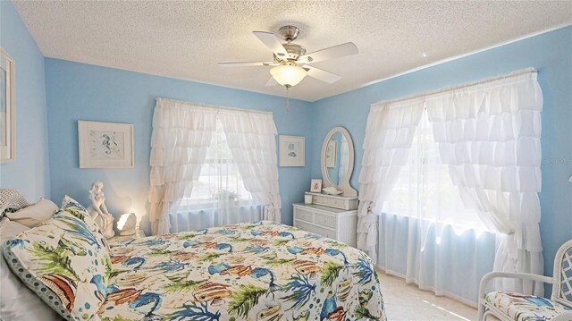 6148 Bonaventure Ct, Sarasota, FL 34243 - tiled bedroom with ceiling fan and a textured ceiling
