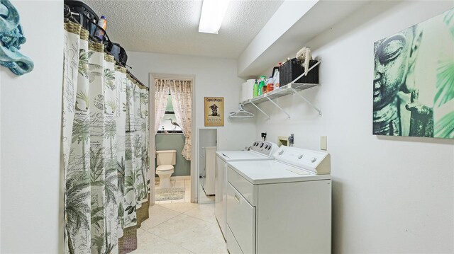 6148 Bonaventure Ct, Sarasota, FL 34243 - clothes washing area featuring light tile patterned floors, a textured ceiling, laundry area, and separate washer and dryer
