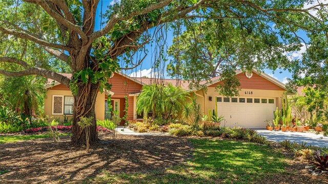 6148 Bonaventure Ct, Sarasota, FL 34243 - ranch-style house featuring stucco siding, an attached garage, and driveway