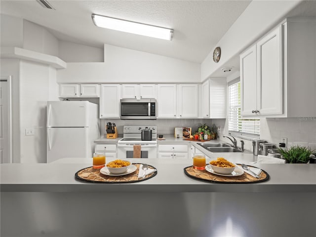 30 N Kaufman Ter, Inverness, FL 34453 - kitchen with white appliances, backsplash, vaulted ceiling, and a sink