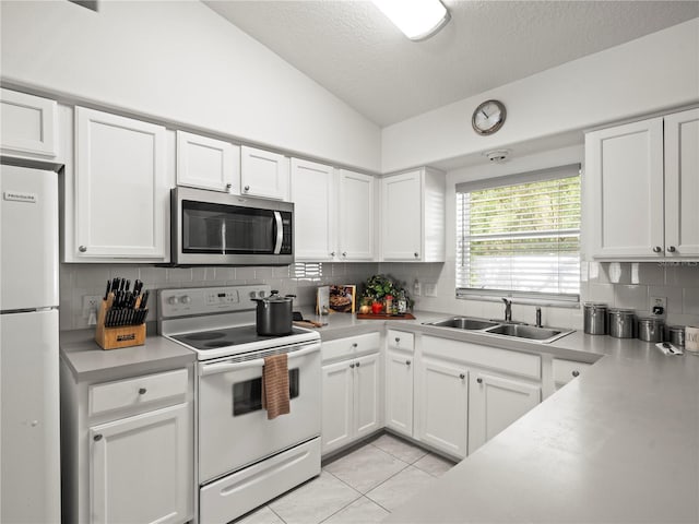 30 N Kaufman Ter, Inverness, FL 34453 - kitchen featuring decorative backsplash, vaulted ceiling, a sink, light countertops, and white appliances