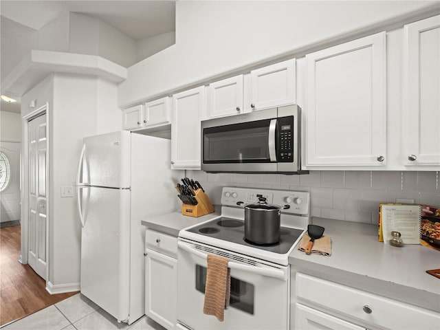 30 N Kaufman Ter, Inverness, FL 34453 - kitchen with light countertops, white cabinetry, white appliances, and tasteful backsplash