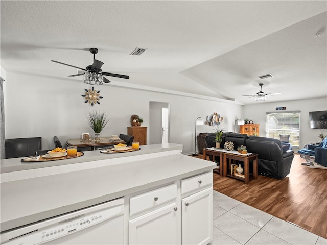 30 N Kaufman Ter, Inverness, FL 34453 - kitchen featuring white dishwasher, ceiling fan, white cabinets, light tile patterned floors, and vaulted ceiling