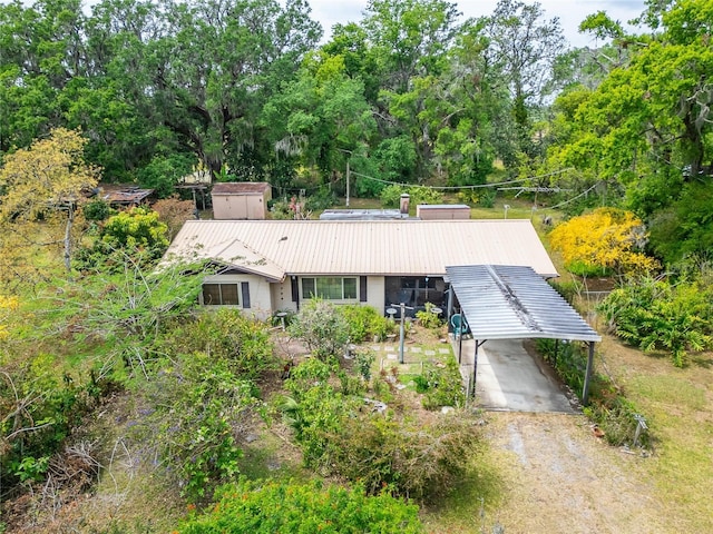 single story home with driveway, metal roof, and a carport