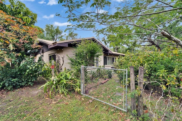 view of property exterior featuring fence and a gate