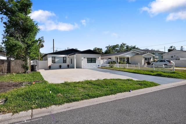 single story home featuring a residential view, fence private yard, driveway, and stone siding