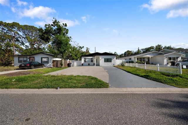 view of front of home with a fenced front yard, a front yard, and concrete driveway
