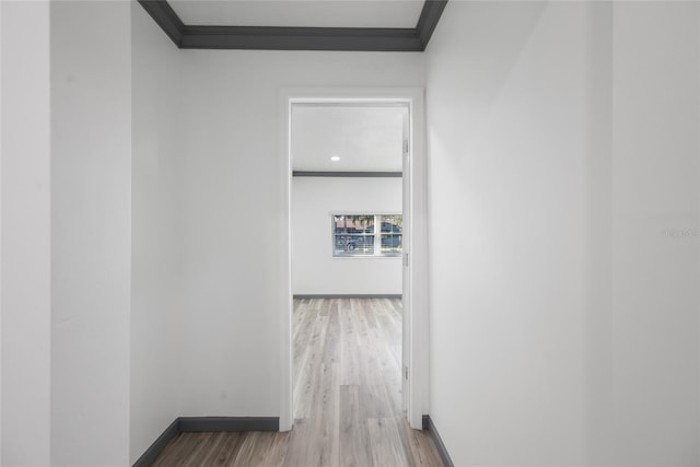 hallway with baseboards, crown molding, and wood finished floors