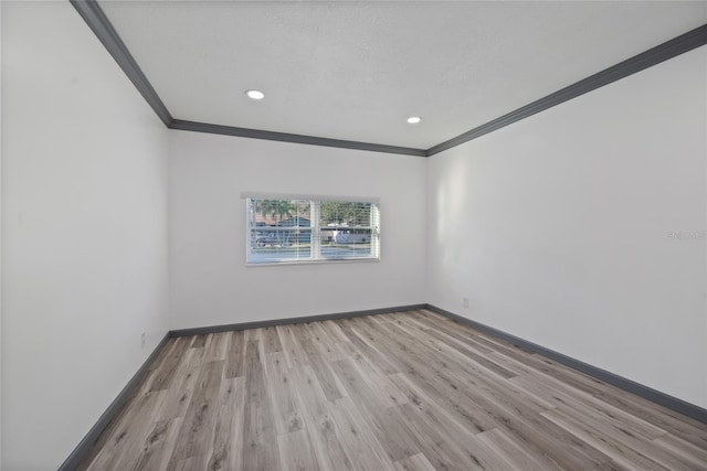 spare room featuring baseboards, wood finished floors, recessed lighting, and crown molding