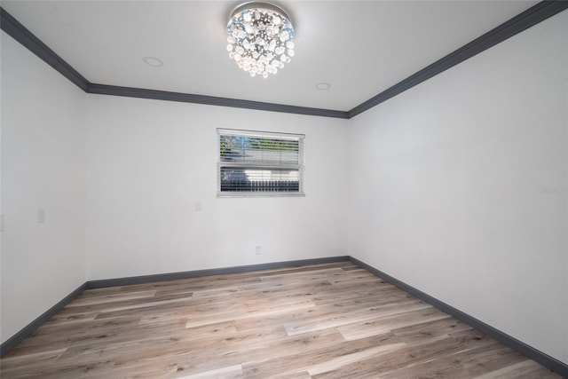 spare room featuring baseboards, ornamental molding, and wood finished floors