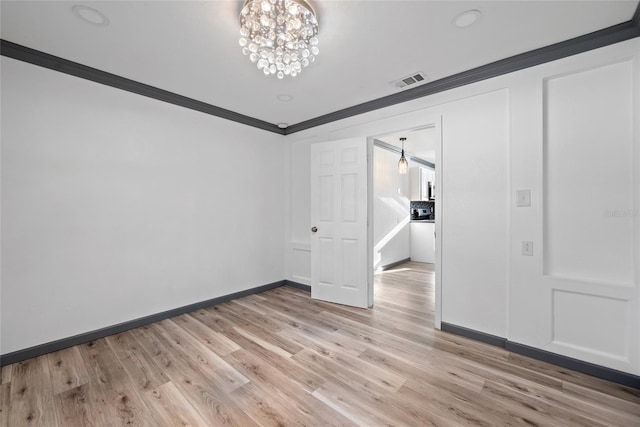 unfurnished bedroom with crown molding, light wood-type flooring, baseboards, a notable chandelier, and visible vents