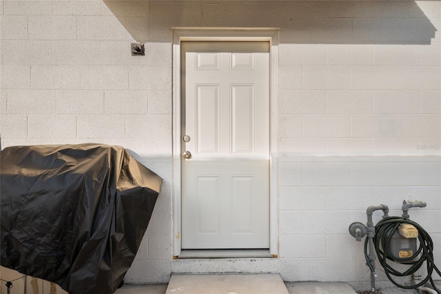 entrance to property featuring concrete block siding