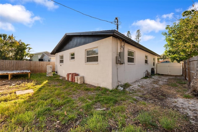 view of side of home with a fenced backyard and concrete block siding