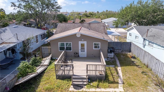 back of house featuring a residential view, a yard, a fenced backyard, central AC, and a deck