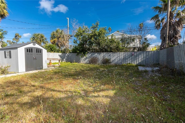 view of yard featuring a fenced backyard, an outbuilding, and a storage shed