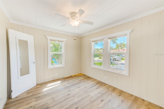 spare room featuring wood finished floors, a ceiling fan, and crown molding