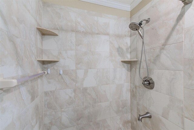 interior details featuring crown molding and a tile shower