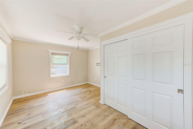 unfurnished bedroom featuring ornamental molding, light wood-type flooring, a closet, and baseboards
