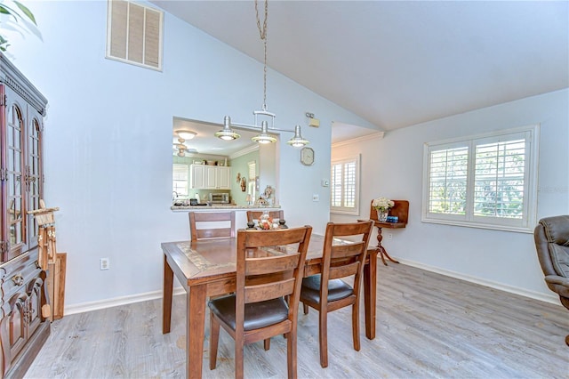5906 Greenbriar Ct, Zephyrhills, FL 33542 - dining space with visible vents, baseboards, high vaulted ceiling, and light wood-style floors