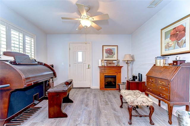 5906 Greenbriar Ct, Zephyrhills, FL 33542 - sitting room with a fireplace, visible vents, a ceiling fan, and wood finished floors