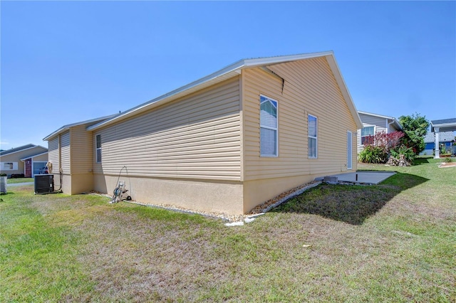 5906 Greenbriar Ct, Zephyrhills, FL 33542 - view of side of home with a yard and central AC unit