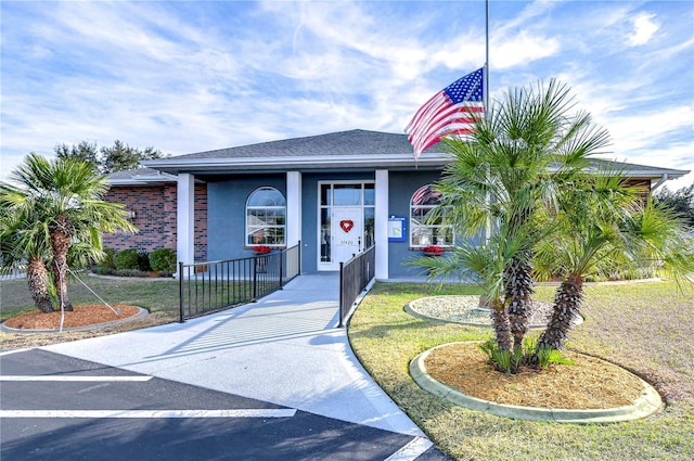 5906 Greenbriar Ct, Zephyrhills, FL 33542 - view of front of property featuring roof with shingles, stucco siding, and a front lawn