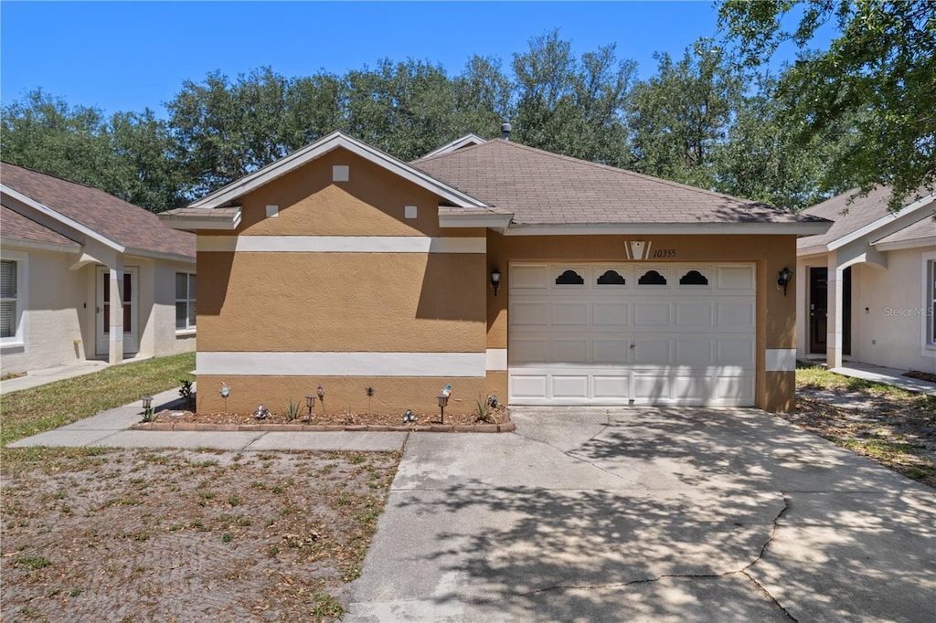 ranch-style home featuring stucco siding, concrete driveway, and a garage