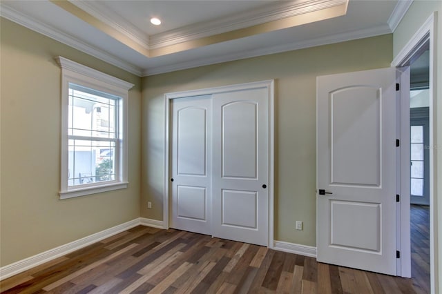 unfurnished bedroom with crown molding, a closet, baseboards, and dark wood-type flooring
