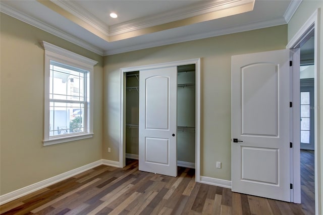 unfurnished bedroom with baseboards, ornamental molding, a closet, and wood finished floors