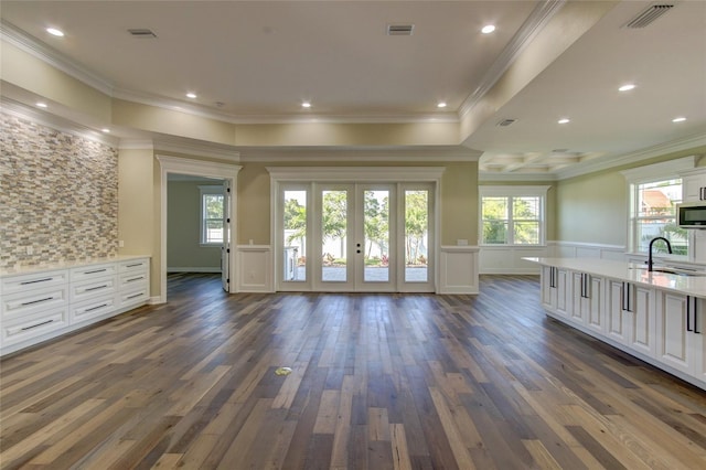 unfurnished living room featuring wainscoting, french doors, dark wood-style flooring, and visible vents