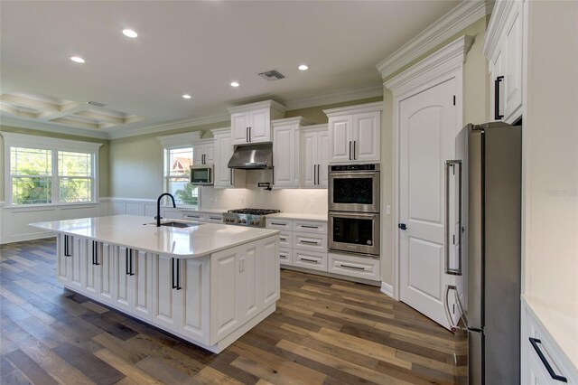kitchen with visible vents, crown molding, appliances with stainless steel finishes, a sink, and under cabinet range hood