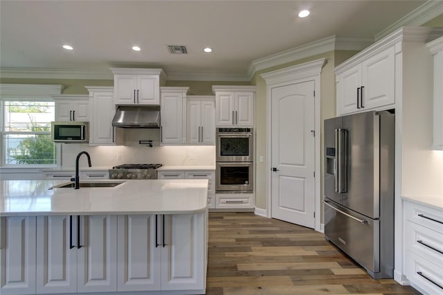 kitchen featuring white cabinets, a sink, stainless steel appliances, under cabinet range hood, and visible vents