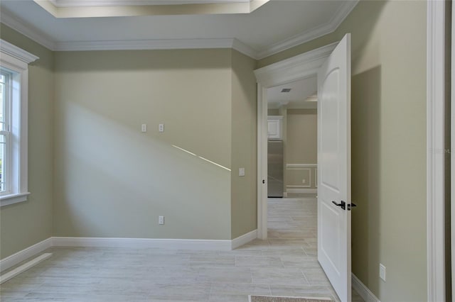 spare room featuring plenty of natural light, ornamental molding, and baseboards