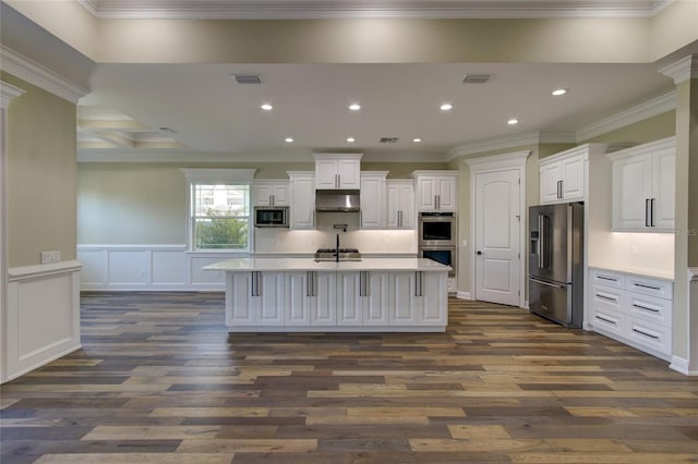 kitchen featuring dark wood-style flooring, light countertops, stainless steel appliances, under cabinet range hood, and visible vents
