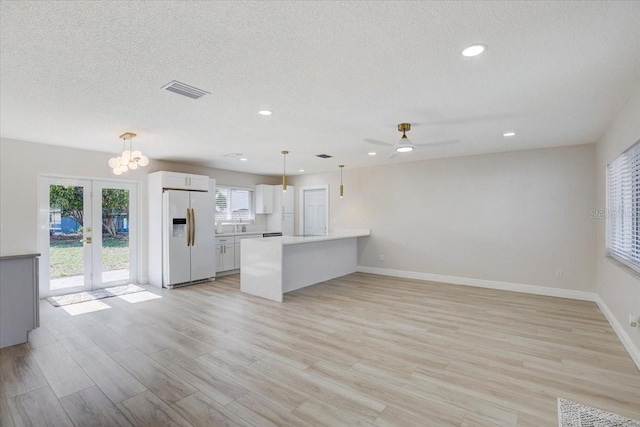 3404 33rd Street Ct W, Bradenton, FL 34205 - kitchen featuring white fridge with ice dispenser, open floor plan, white cabinets, light countertops, and french doors