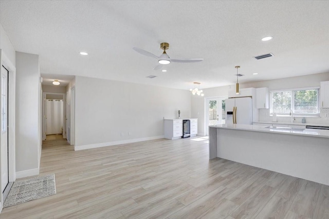 3404 33rd Street Ct W, Bradenton, FL 34205 - unfurnished living room featuring ceiling fan, light wood finished floors, recessed lighting, baseboards, and a chandelier