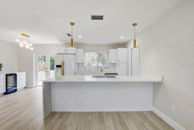 3404 33rd Street Ct W, Bradenton, FL 34205 - kitchen featuring white refrigerator with ice dispenser, white cabinetry, light countertops, light wood-style floors, and recessed lighting