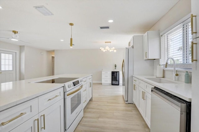 3404 33rd Street Ct W, Bradenton, FL 34205 - kitchen with white electric stove, dishwasher, a sink, freestanding refrigerator, and healthy amount of natural light