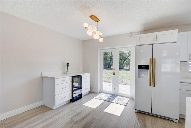 3404 33rd Street Ct W, Bradenton, FL 34205 - bar featuring white refrigerator with ice dispenser, wine cooler, french doors, light wood finished floors, and a textured ceiling