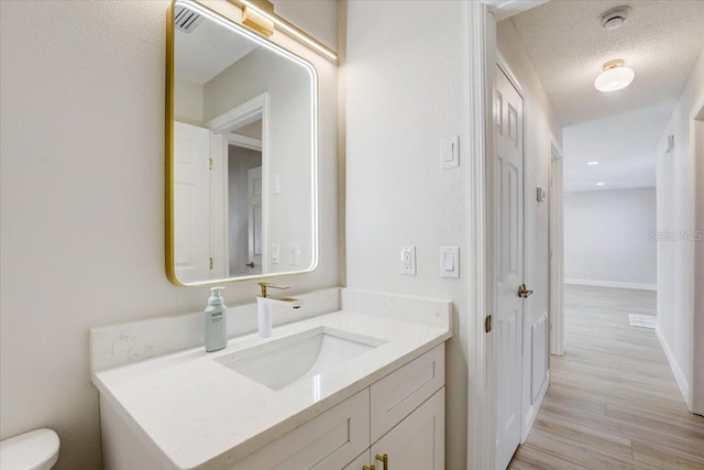 3404 33rd Street Ct W, Bradenton, FL 34205 - bathroom featuring toilet, vanity, wood finished floors, baseboards, and a textured ceiling
