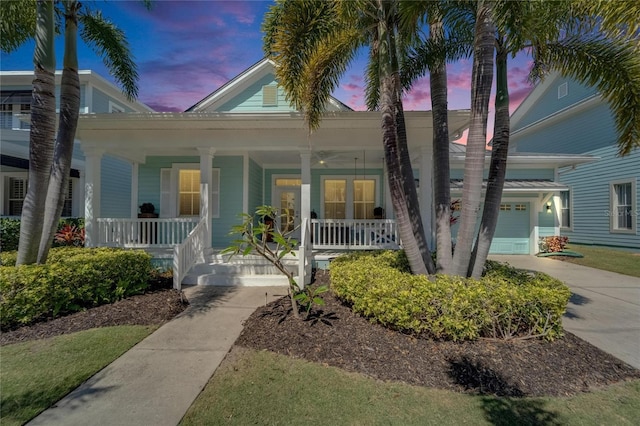 view of front of house with a garage, covered porch, and driveway